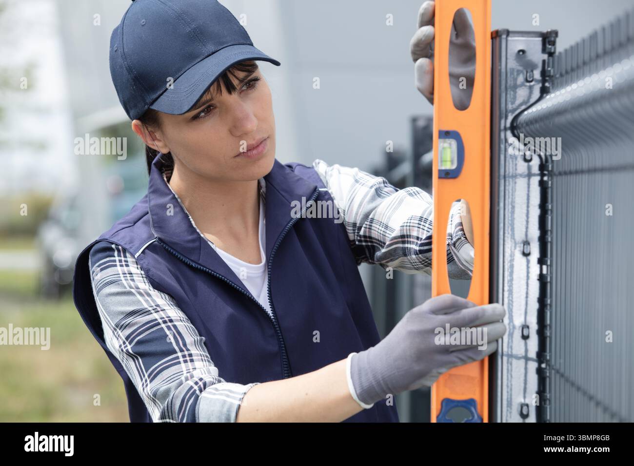 female builder using a spirit level Stock Photo