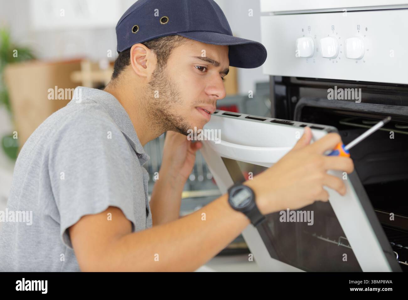 young male worker installing new oven Stock Photo