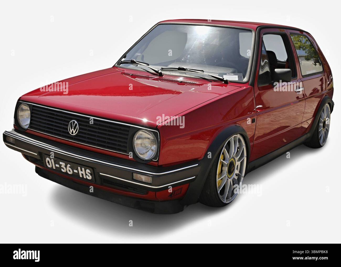 Customized red Volkswagen Golf GTI Mk2 parking on a white background Stock Photo