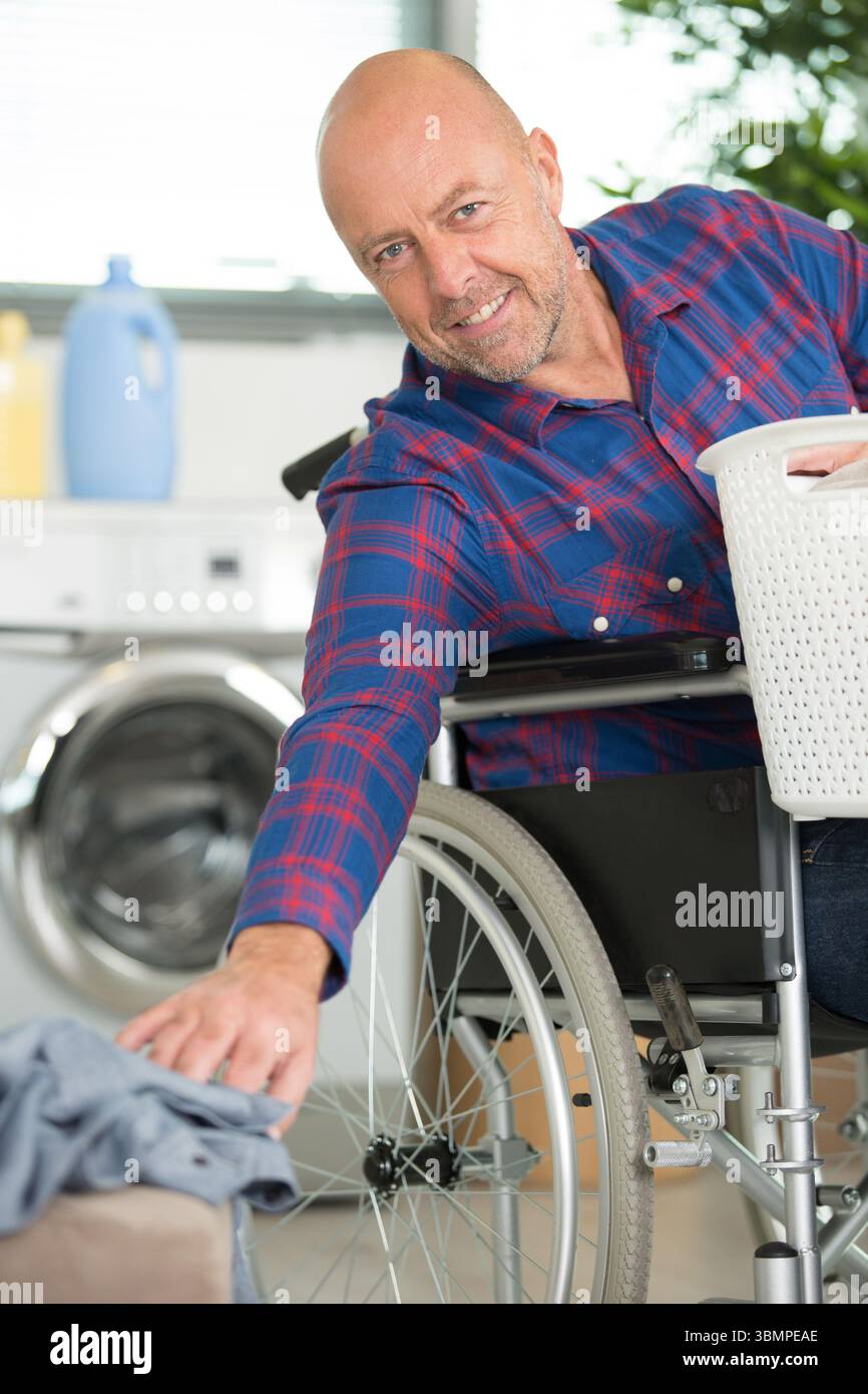 disabled man on wheelchair doing laundry Stock Photo