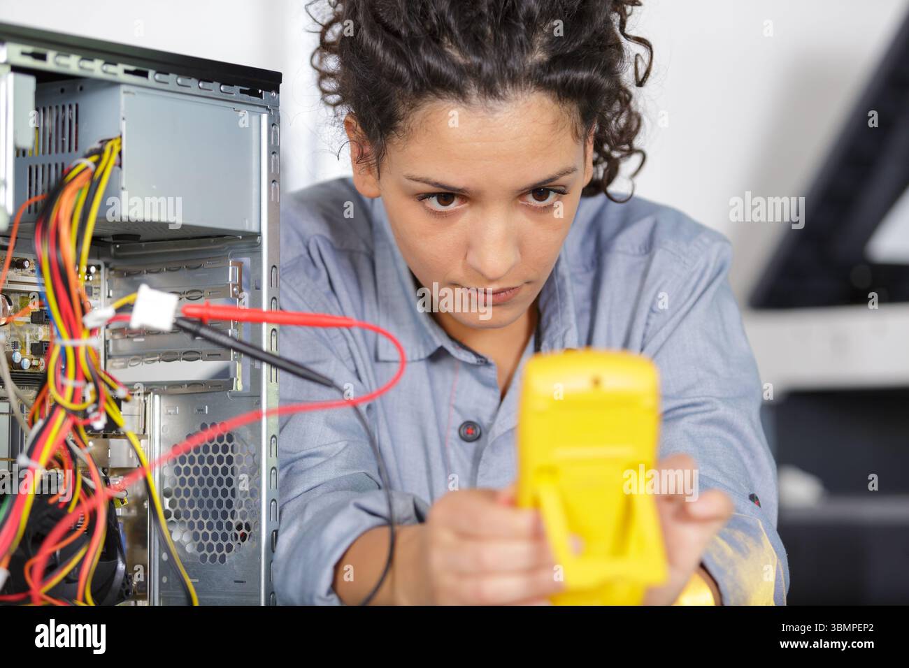 female technician using voltage meter for voltage measurement Stock Photo