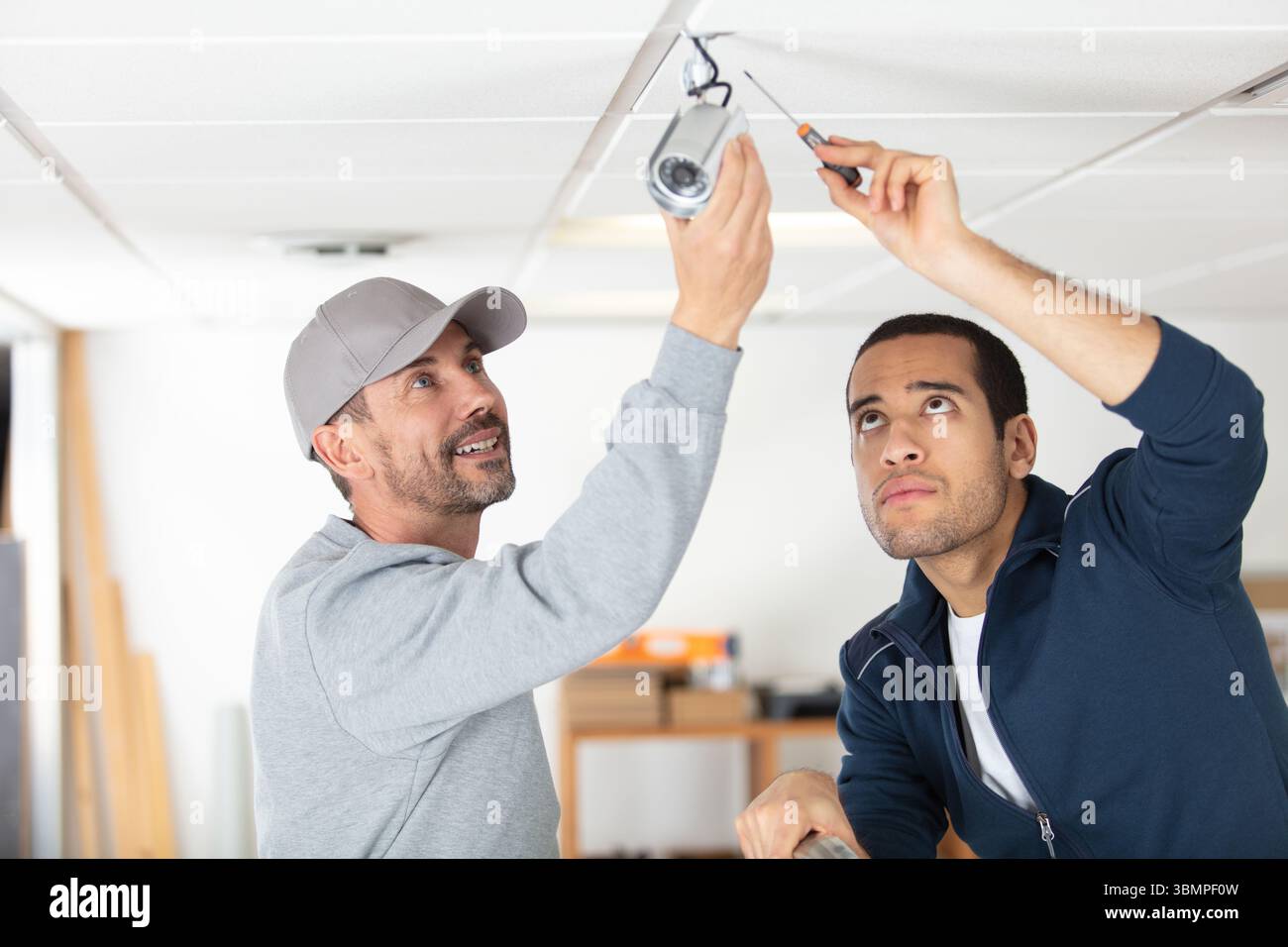 technicians installing security camera system at home Stock Photo