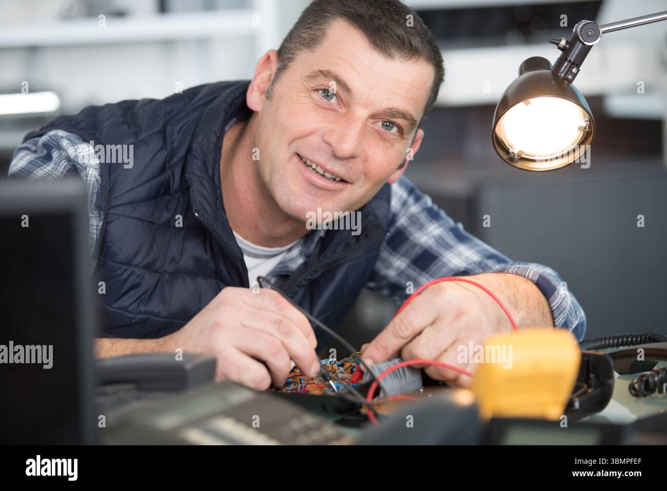 smiling handsome electrician checking electrical system Stock Photo