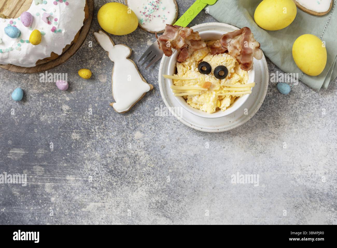 Easter breakfast idea. Scrambled eggs easter bunny on a stone background. View from above. Copy space Stock Photo