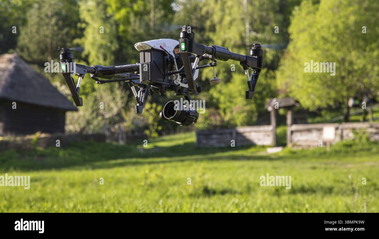 Flying copter with raised chassis and a camera is filming in the ...
