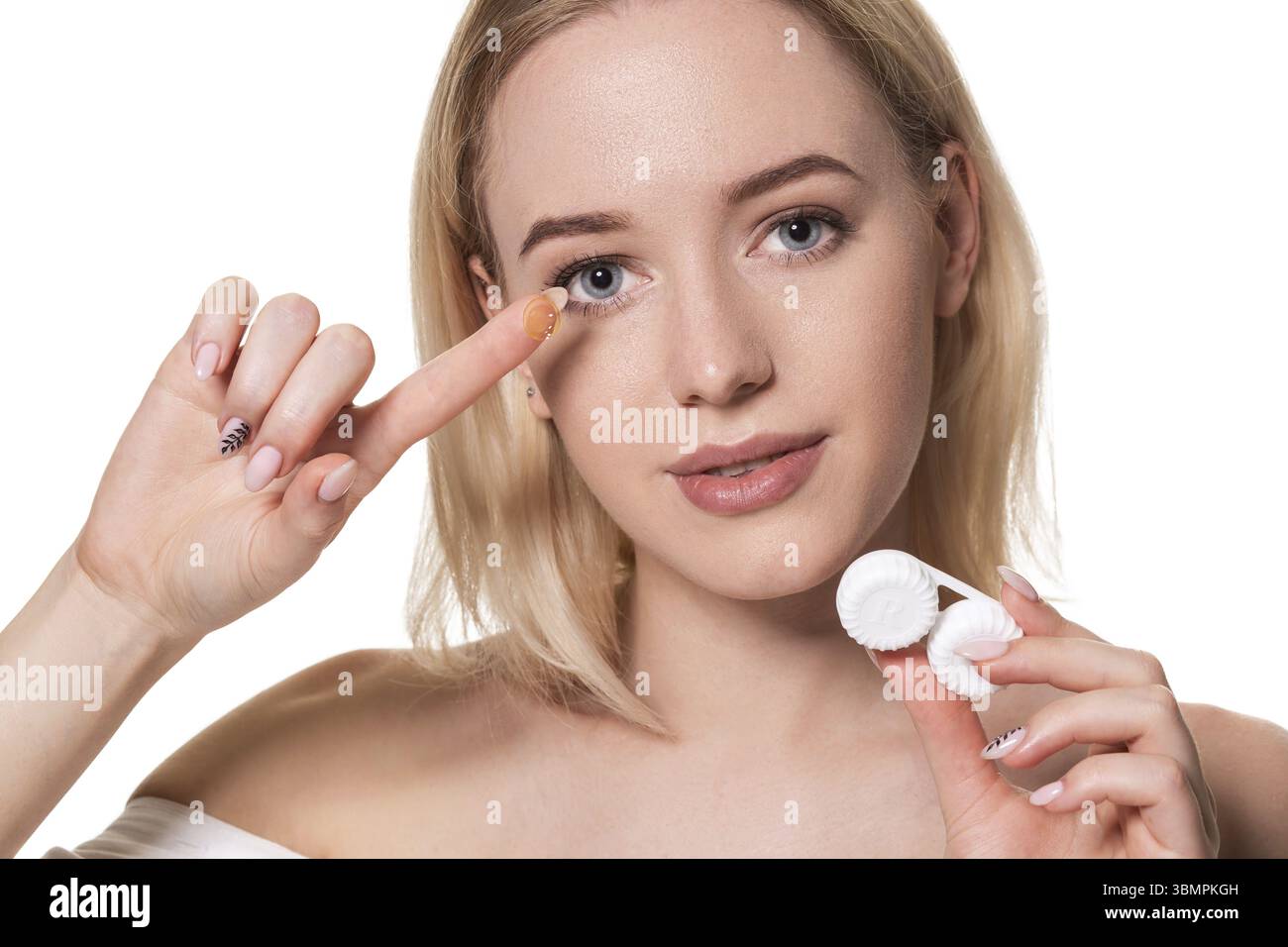 Young woman holding contact lenses cases and lens in front of her face ...
