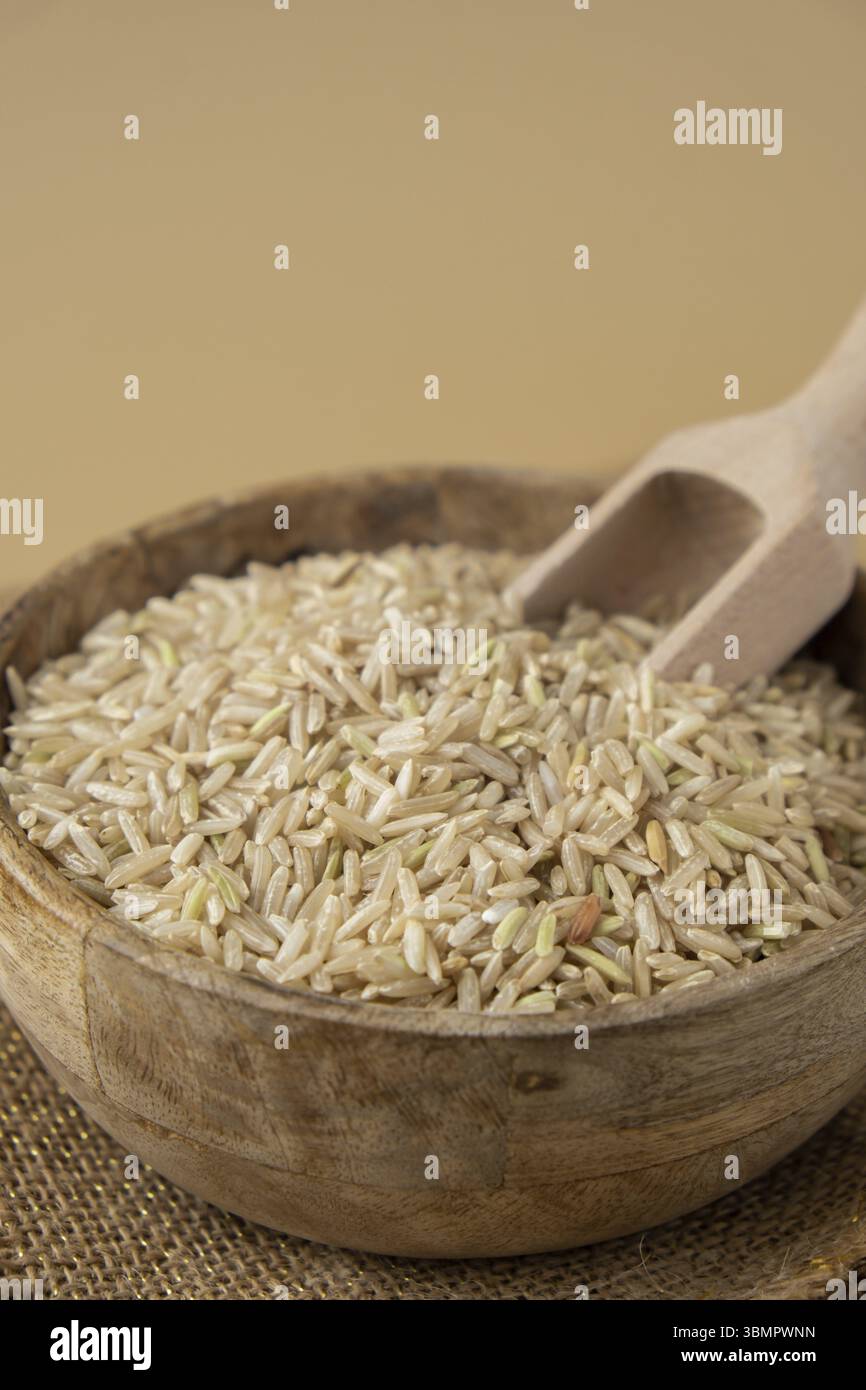 Brown rice in neutral beige background copy space. Whole spelt grain ...