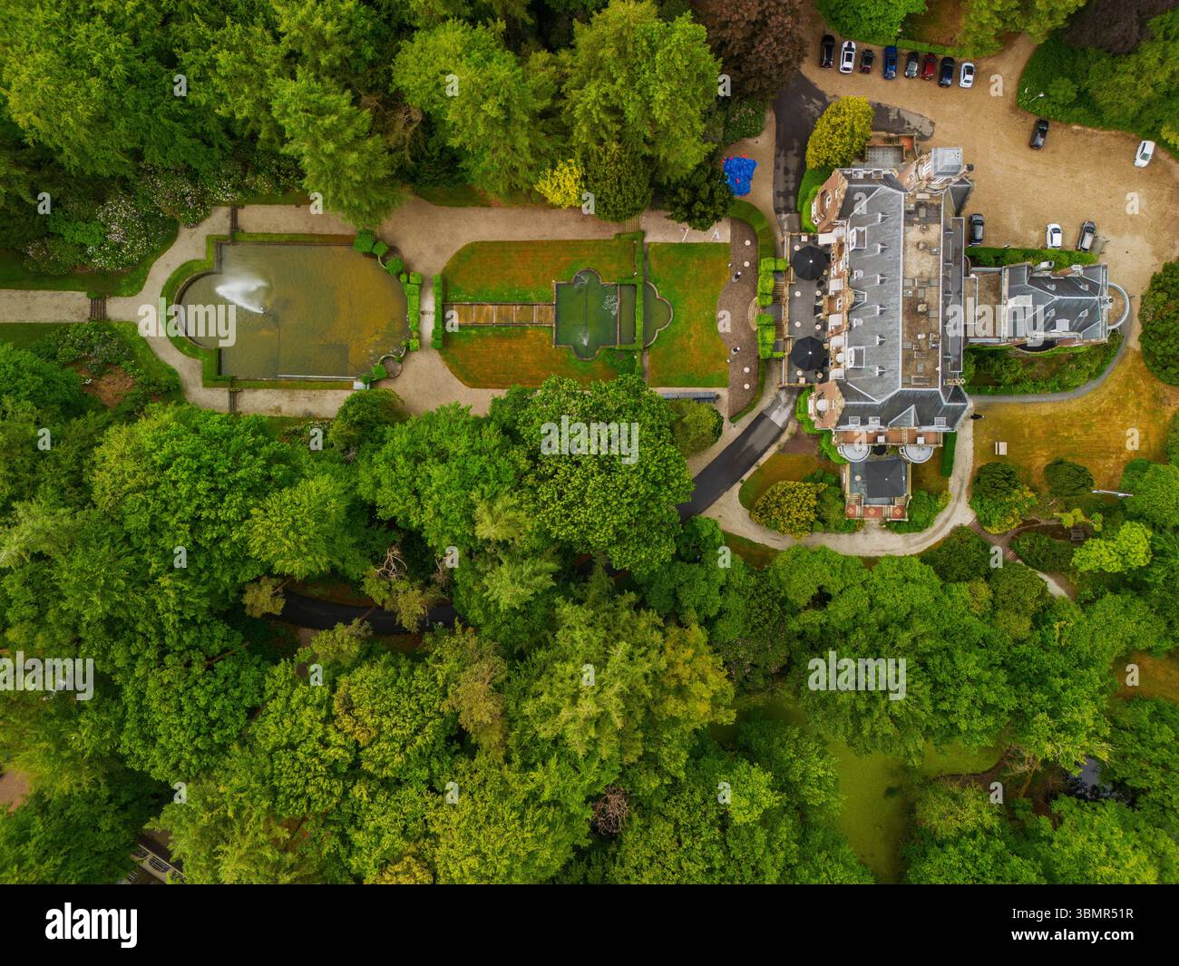 An aerial view of a historic mansion surrounded by lush green trees and ...