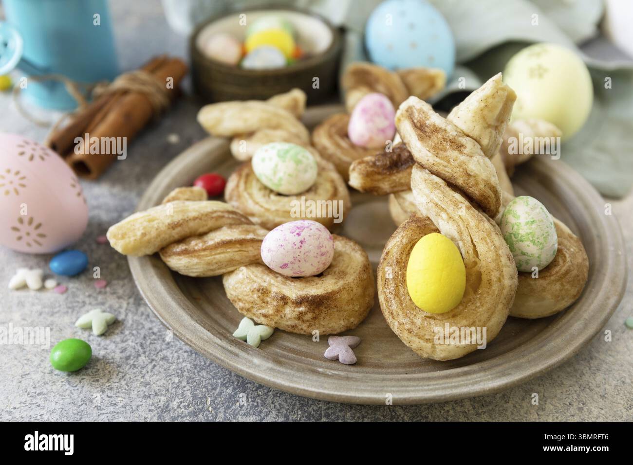 Easter rabbit-shaped buns puff pastry with cinnamon on a stone tabletop. Easter bake idea Stock Photo