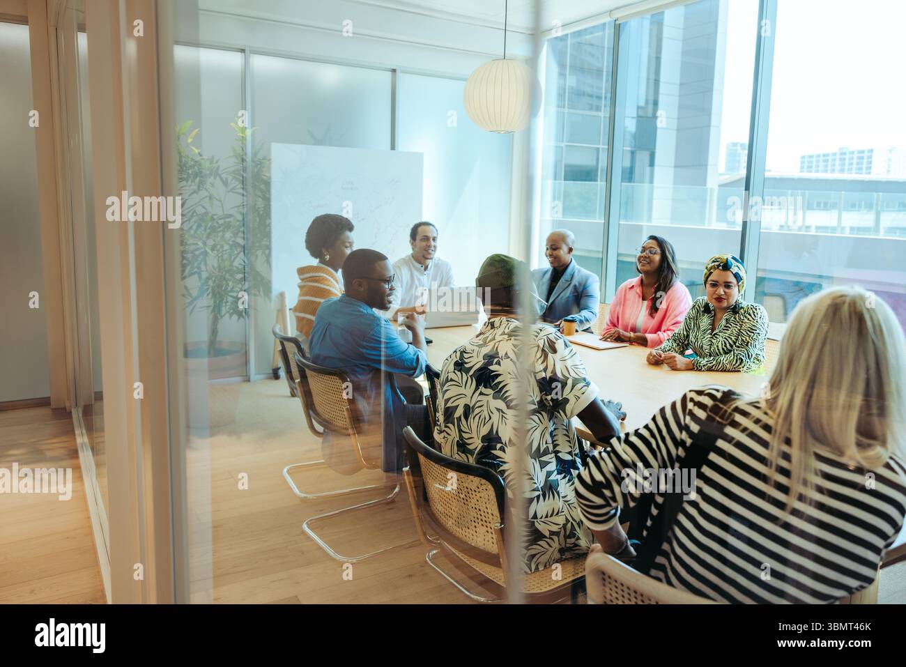 A diverse group of professionals gathers around a large conference table to brainstorm and collaborate on innovative ideas. The essence of teamwork an Stock Photo