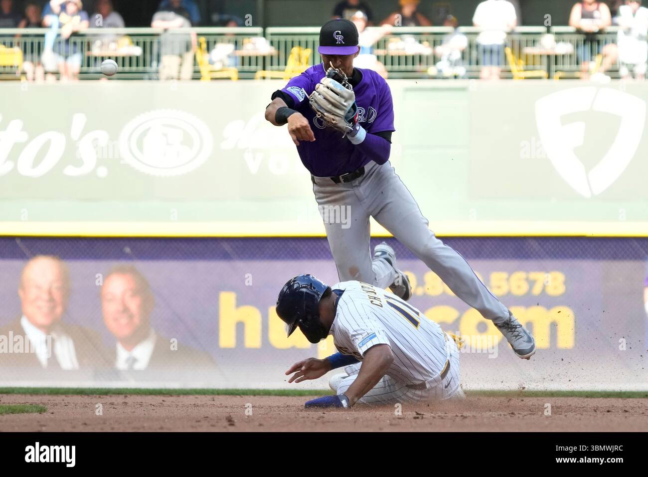 Colorado Rockies shortstop Ryan Ritter, top, hurdles Milwaukee Brewers ...