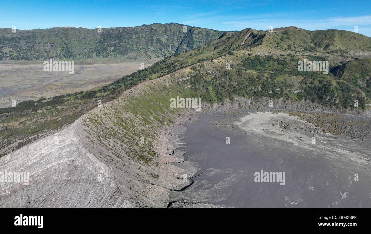 From above the rim of Mount Bromo, green slopes contrast with the ashen ...