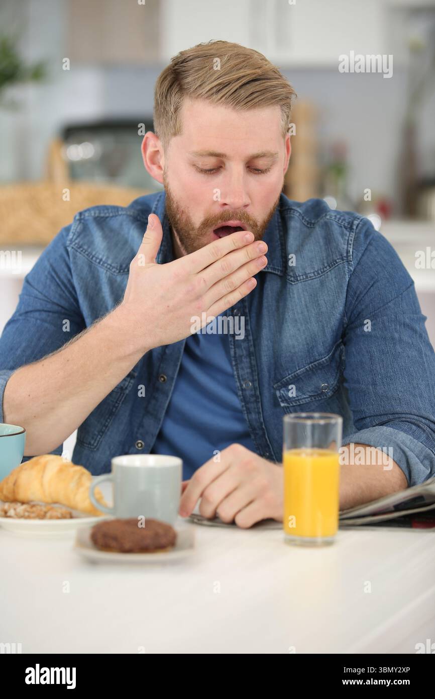 man falling asleep during his breakfast Stock Photo
