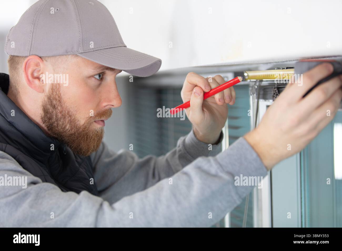 man measuring window prior to installation Stock Photo