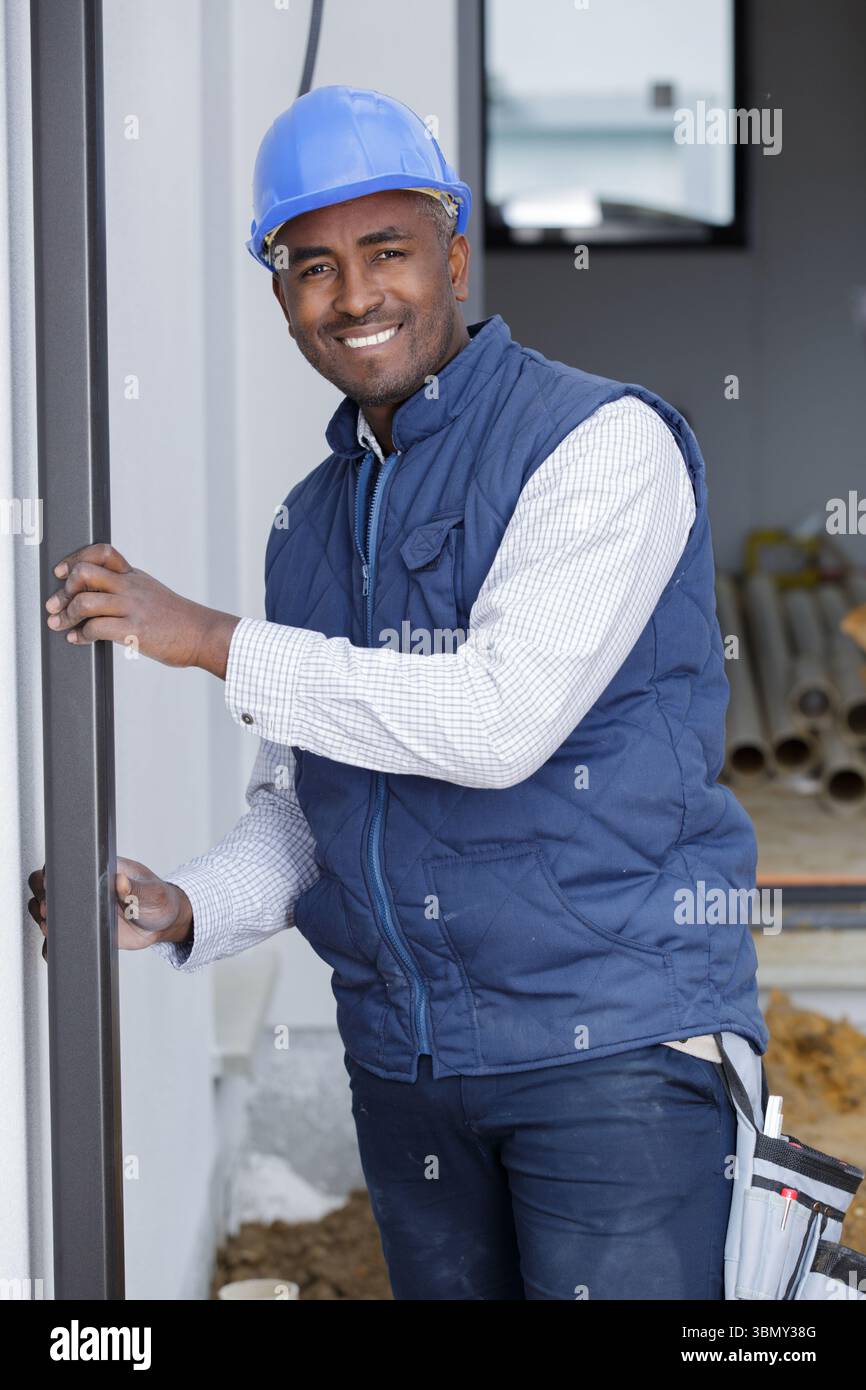 construction worker using bubble level while installing window indoors Stock Photo