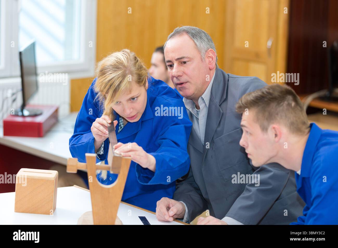 carpenter with students in workshop Stock Photo