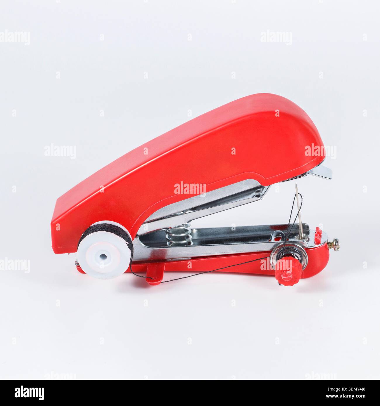 It is Red handheld sewing machine isolated on white. Stock Photo