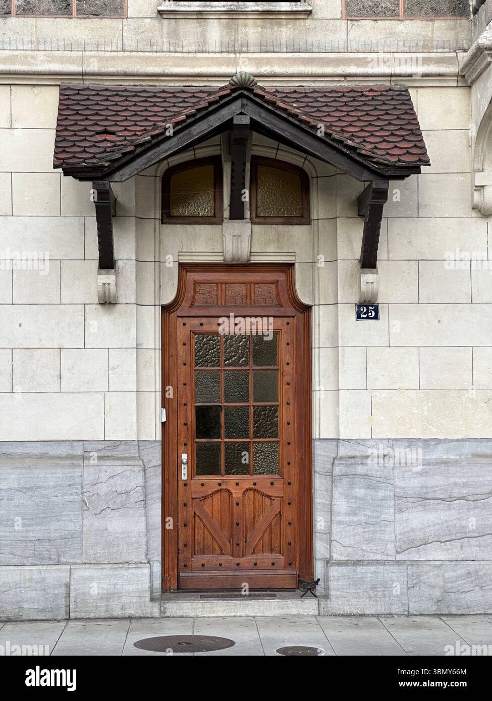A beautifully crafted wooden door is the focal point of this classic building exterior. - Smartphone Captured Stock Image