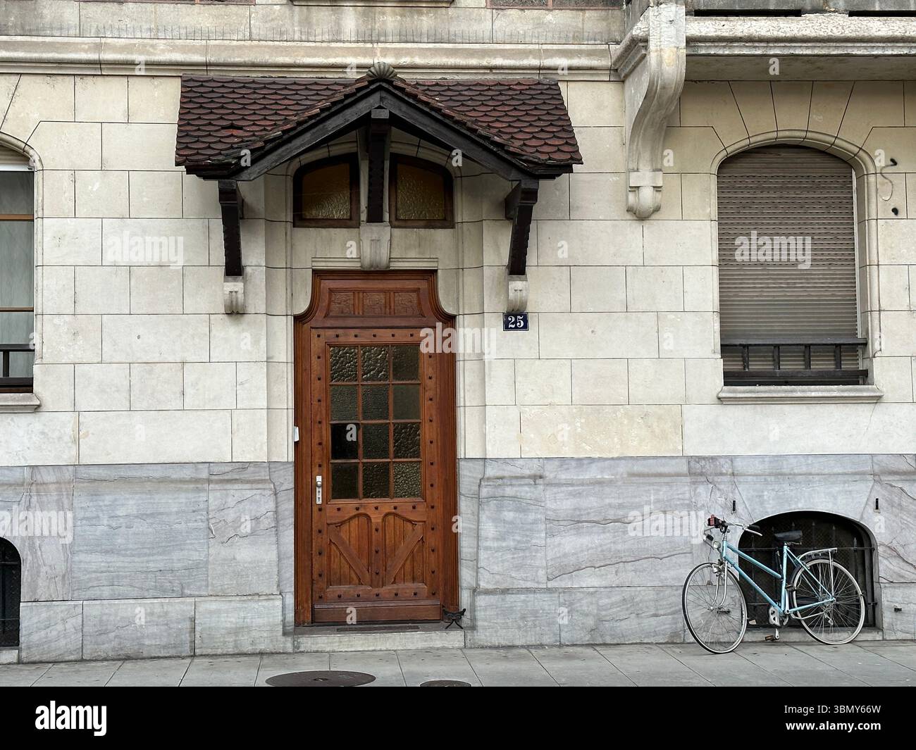 A beautifully crafted wooden door is the focal point of this classic building exterior. - Smartphone Captured Stock Image