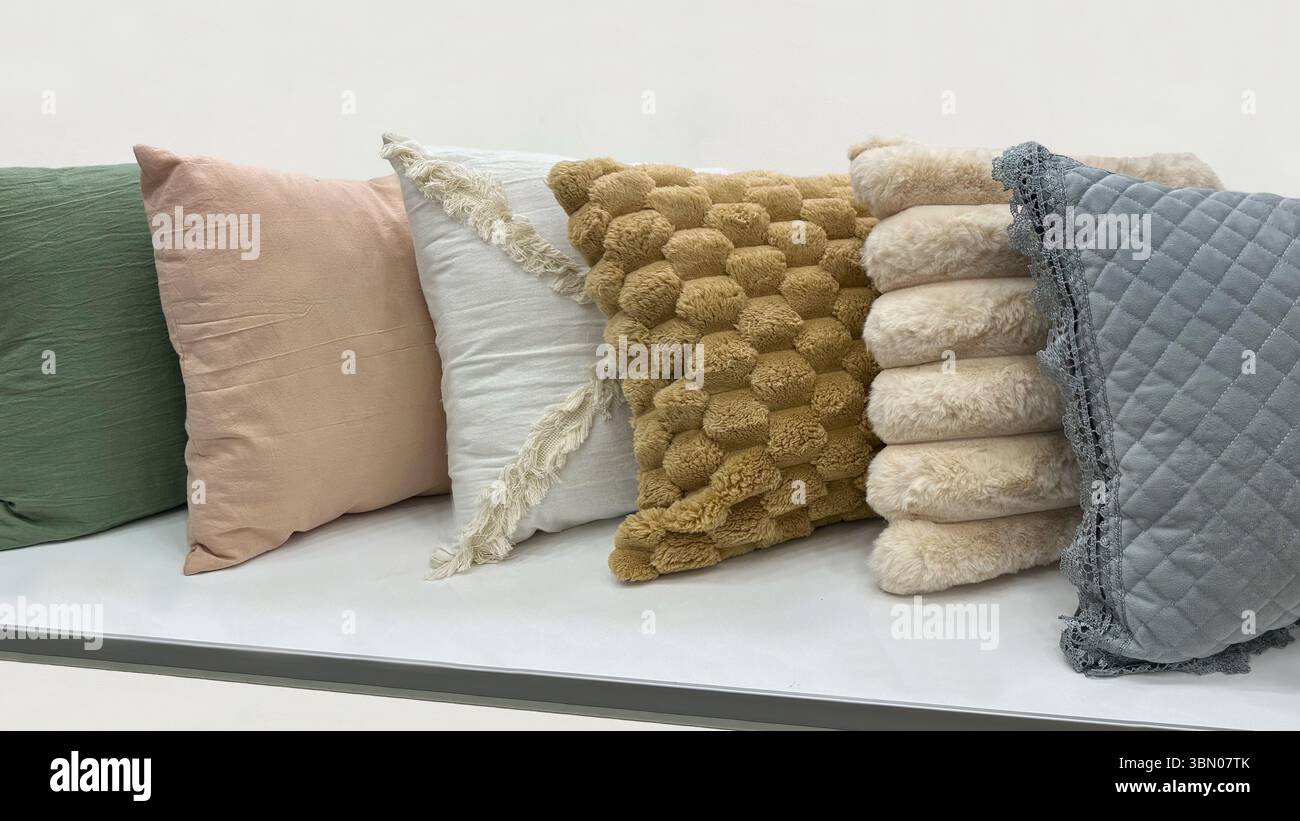 Line of decorative throw pillows in various colors and textures, perfect for cozy and stylish home decor. Stock Photo