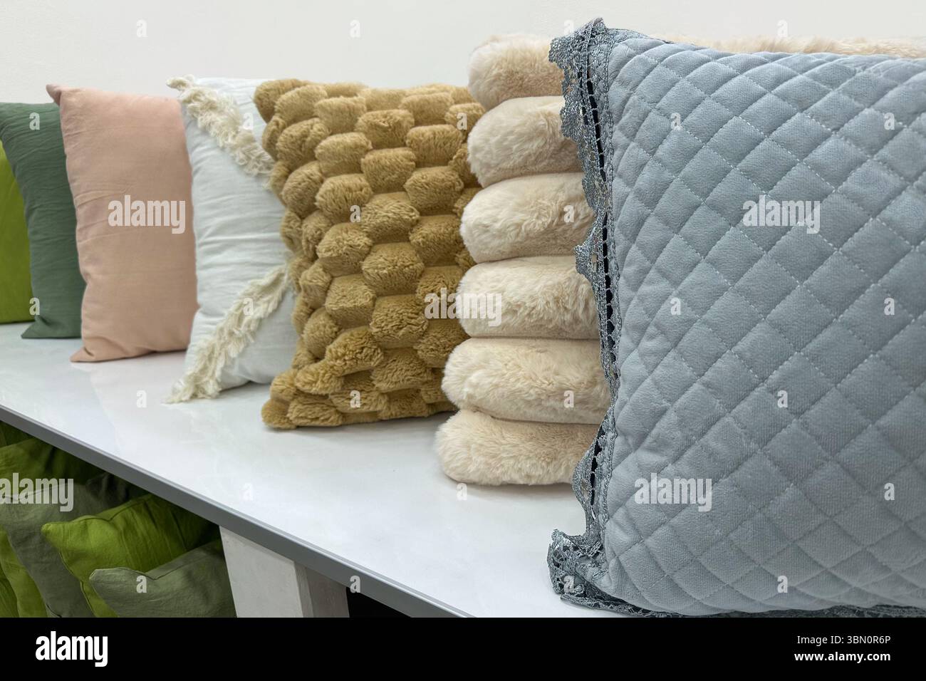 Line of decorative throw pillows in various colors and textures, perfect for cozy and stylish home decor. Stock Photo
