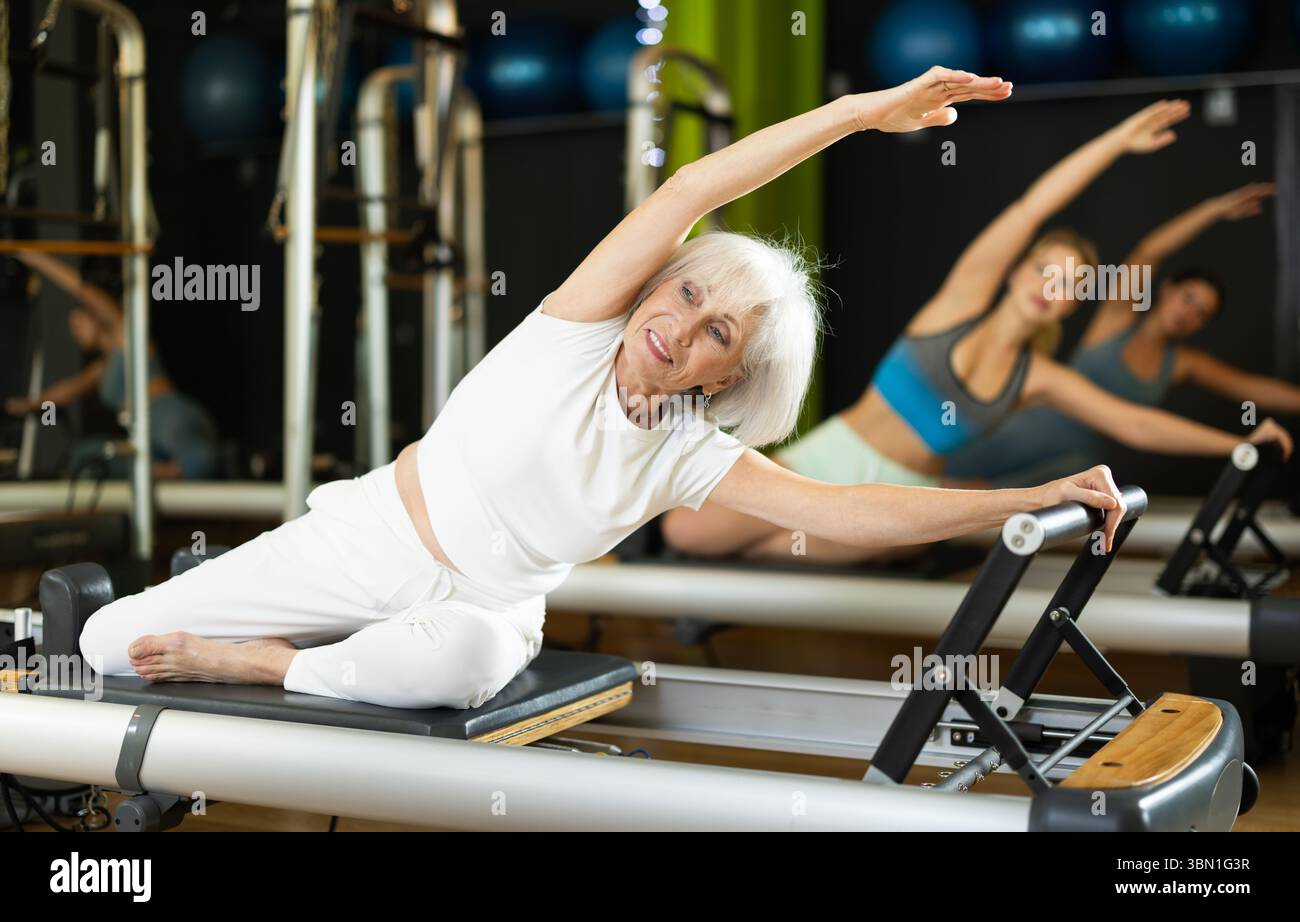 Elderly woman doing side bends Stock Photo