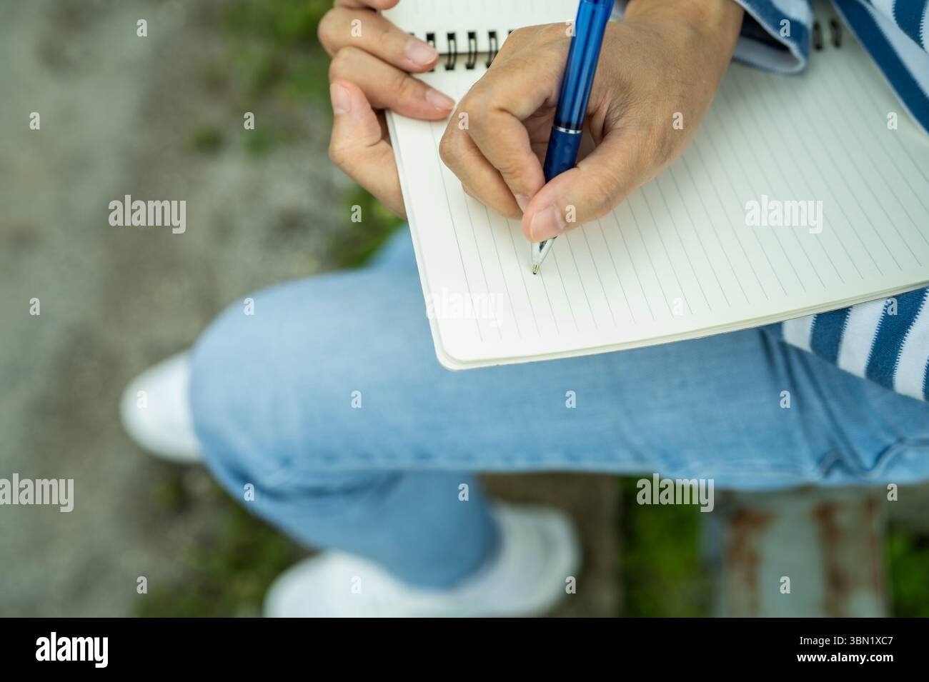 Reflection Writing Notebook Close-up of woman's hand writing in notebook outdoors. Self-reflection ...