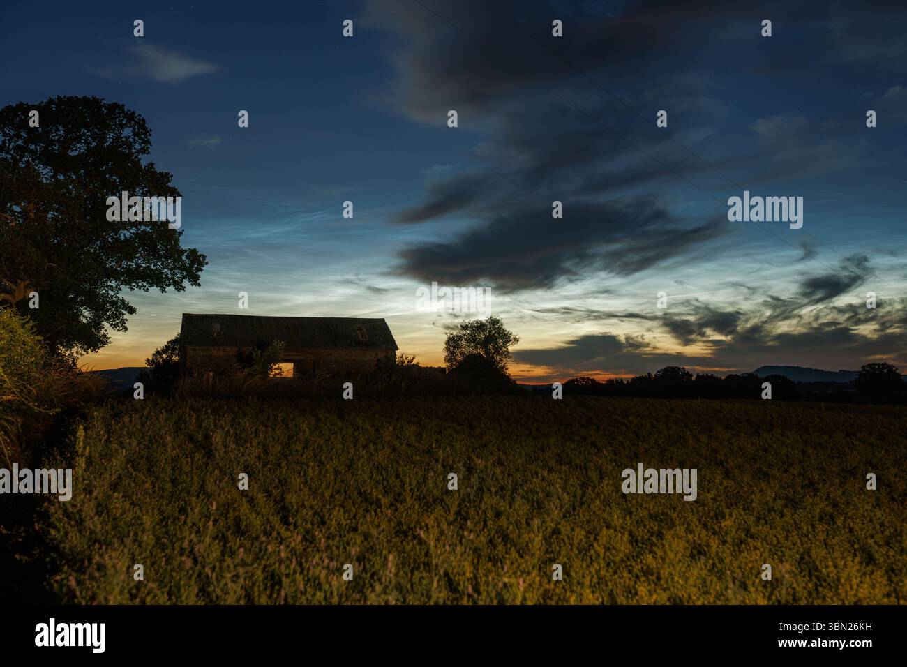 Farm barn by night under a Noctilucent cloud night Stock Photo