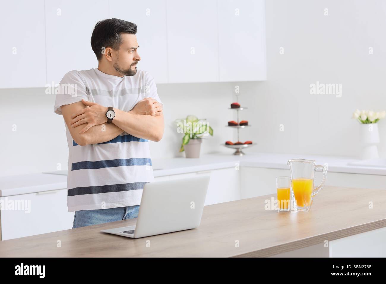 Young man having panic attack in kitchen Stock Photo