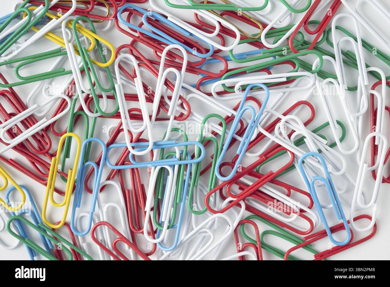 Multicolored paper clips on a white background, texture background Stock Photo