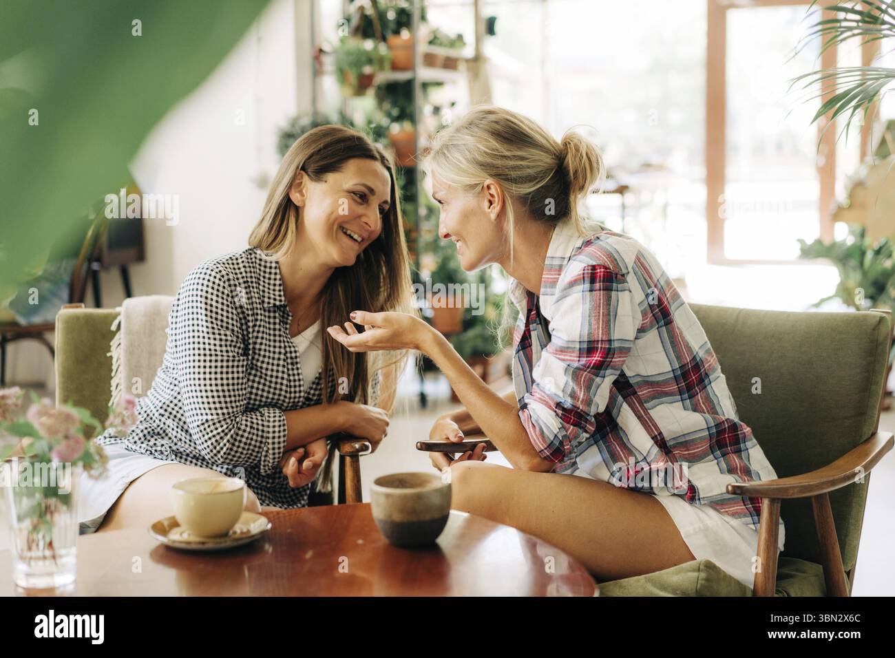 Two women are having a trust conversation while sitting in a restaurant Stock Photo