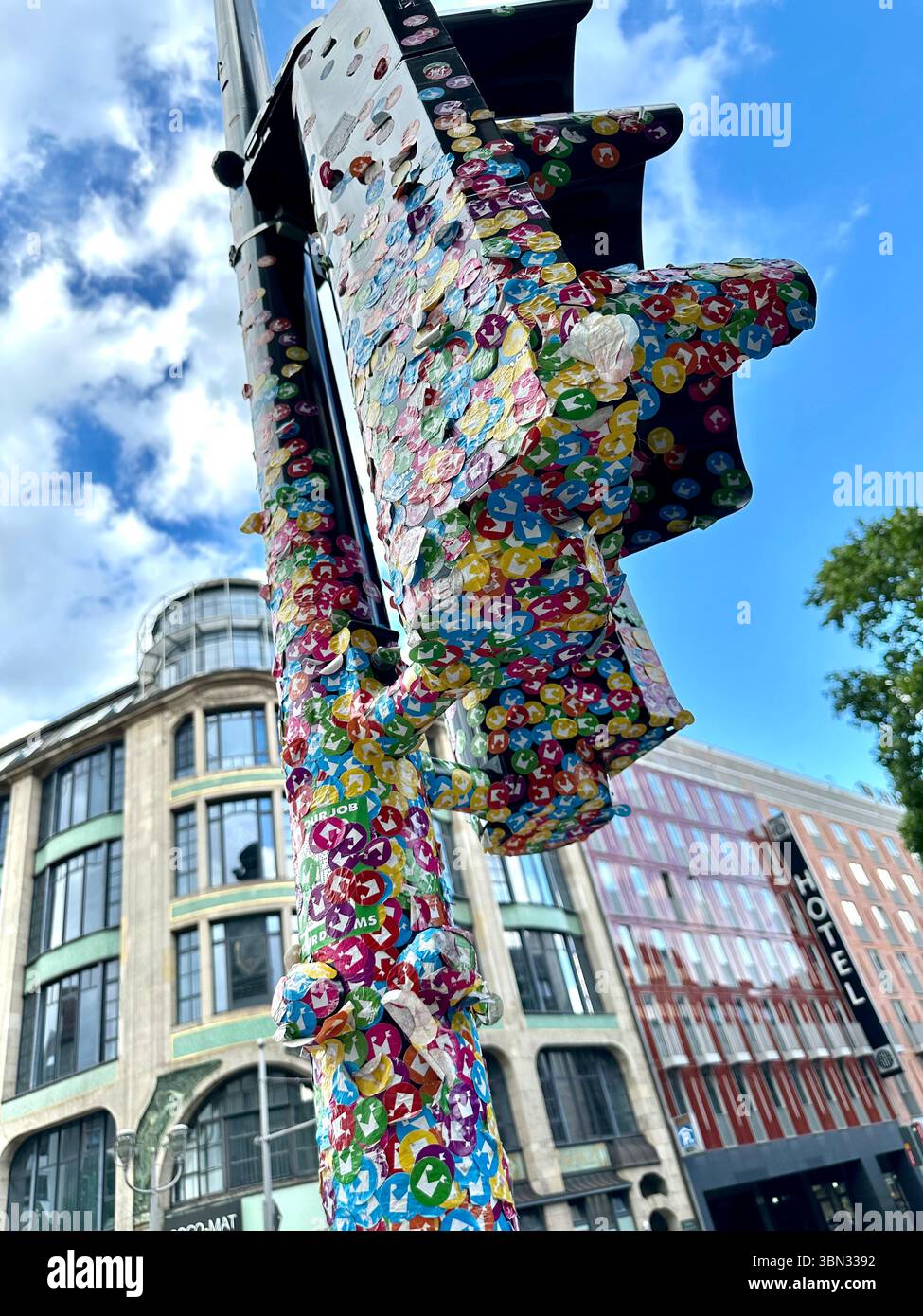 Set of traffic lights covered in stickers for the Museum for Communication, has been transformed into a piece of public art in Berlin, Germany - Smartphone Captured Stock Image