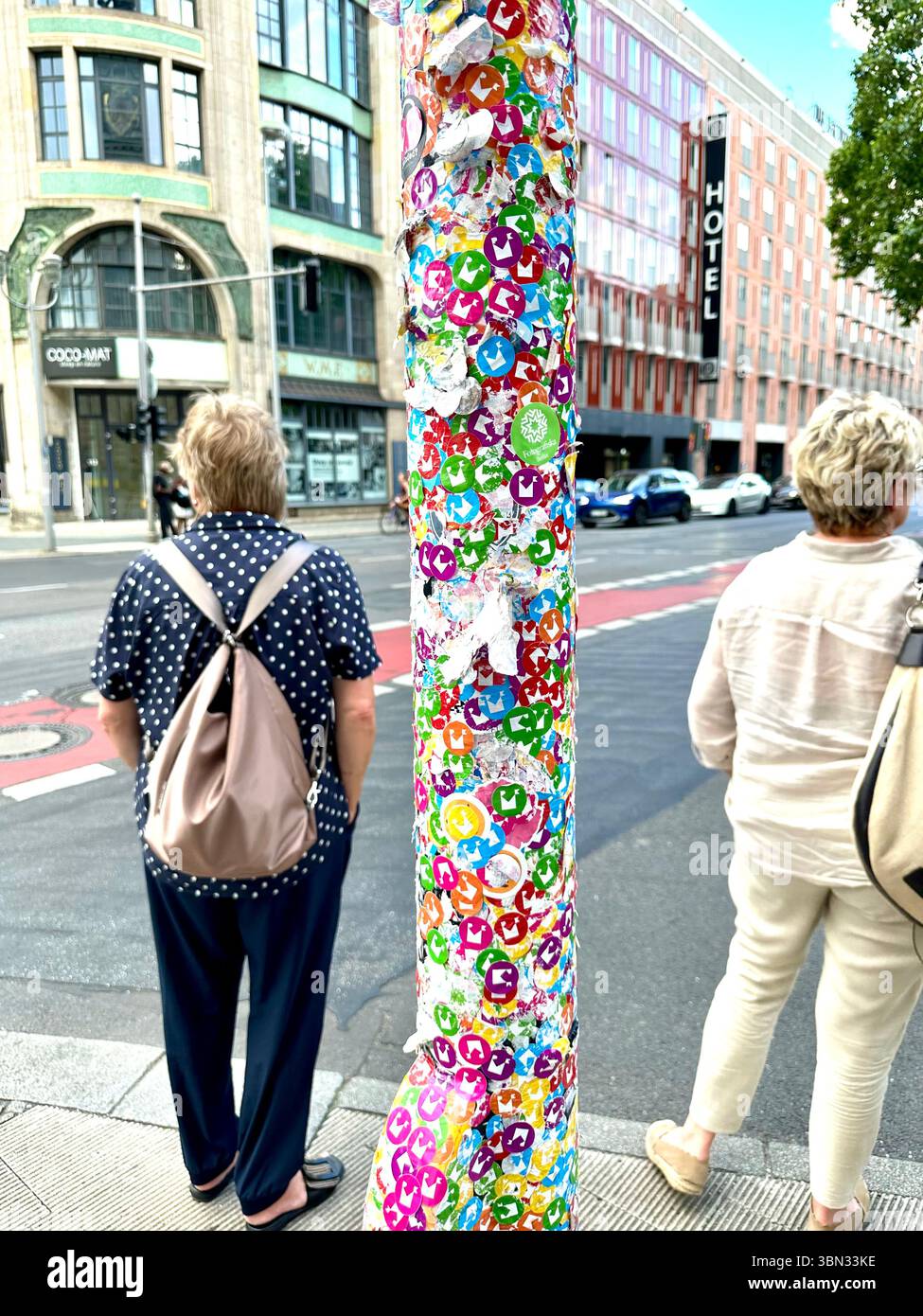 A traffic light pole covered in stickers for the Museum for Communication, has been transformed into a piece of public art in Berlin, Germany - Smartphone Captured Stock Image