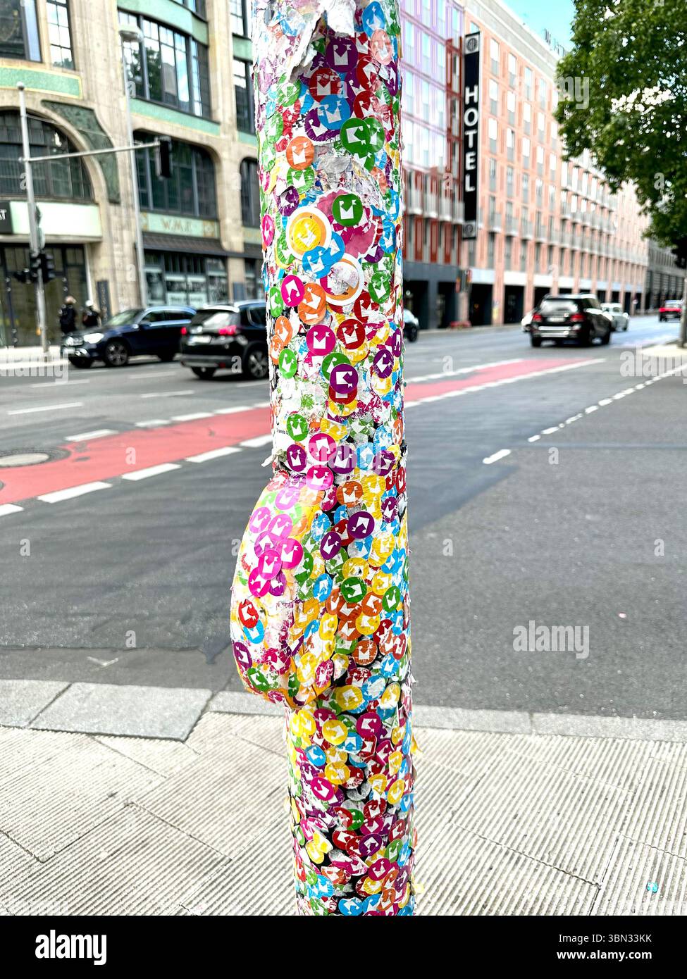 A traffic light pole covered in stickers for the Museum for Communication, has been transformed into a piece of public art in Berlin, Germany - Smartphone Captured Stock Image