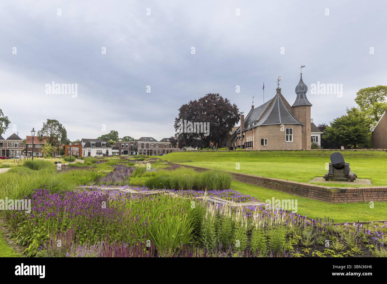 Scenic view of beautiful park and garden with purple and blue flowers near the city hall and castle and canon of Coevorden in Drenthe The Netherlands Stock Photo