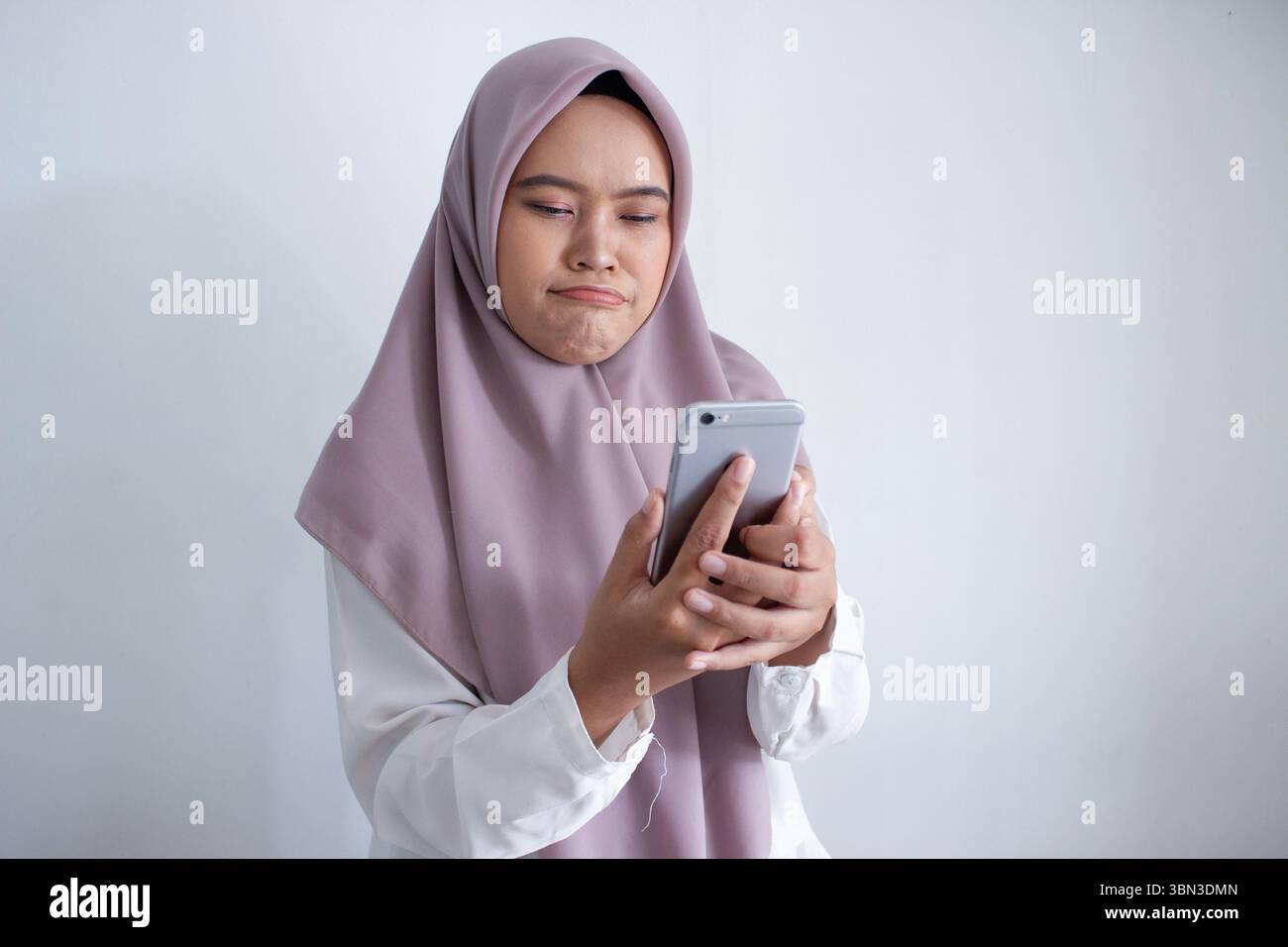 young muslim asian woman wearing a purple hijab head scarf is looking ...