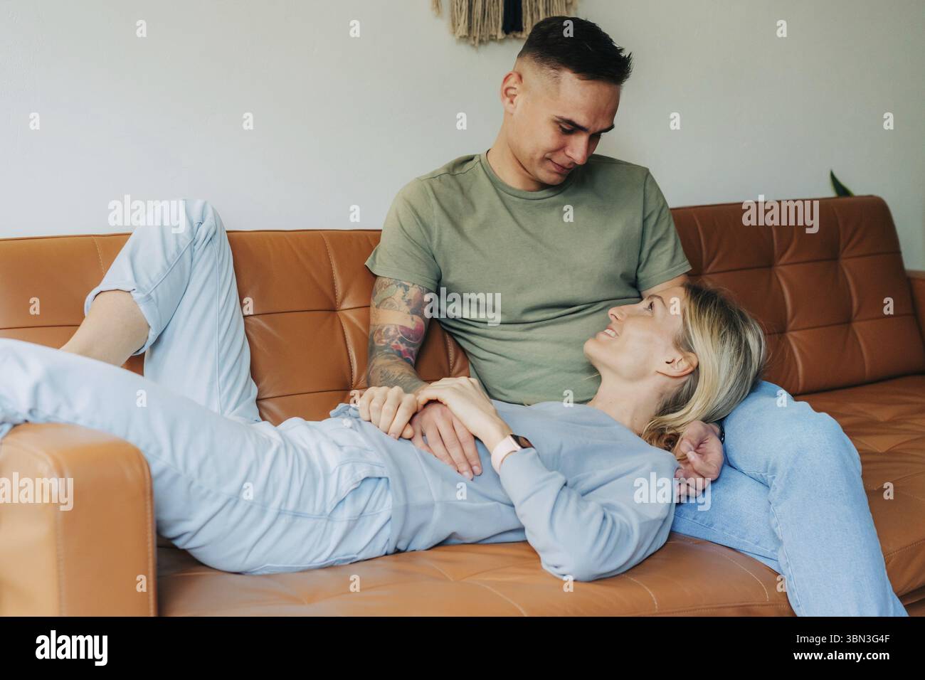 Zaertliches Paar entspannt zusammen auf dem Sofa Stock Photo
