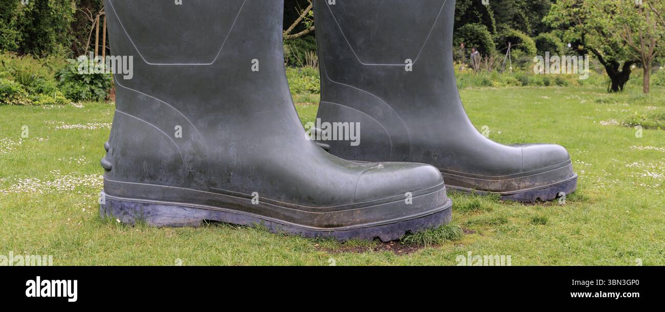 Magnified gray rain boots standing in a garden Stock Photo