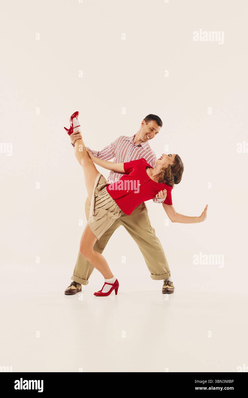 Lindy hop dancers in vintage attire performing energetic retro swing dance moves Stock Photo