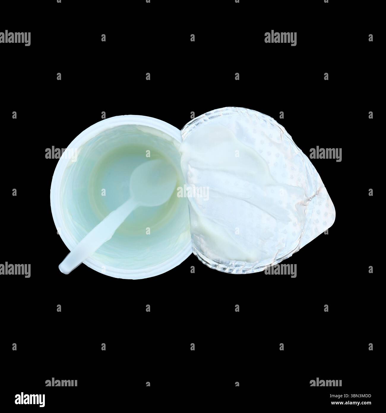 it is empty yoghurt cup with spoon isolated on black. Stock Photo