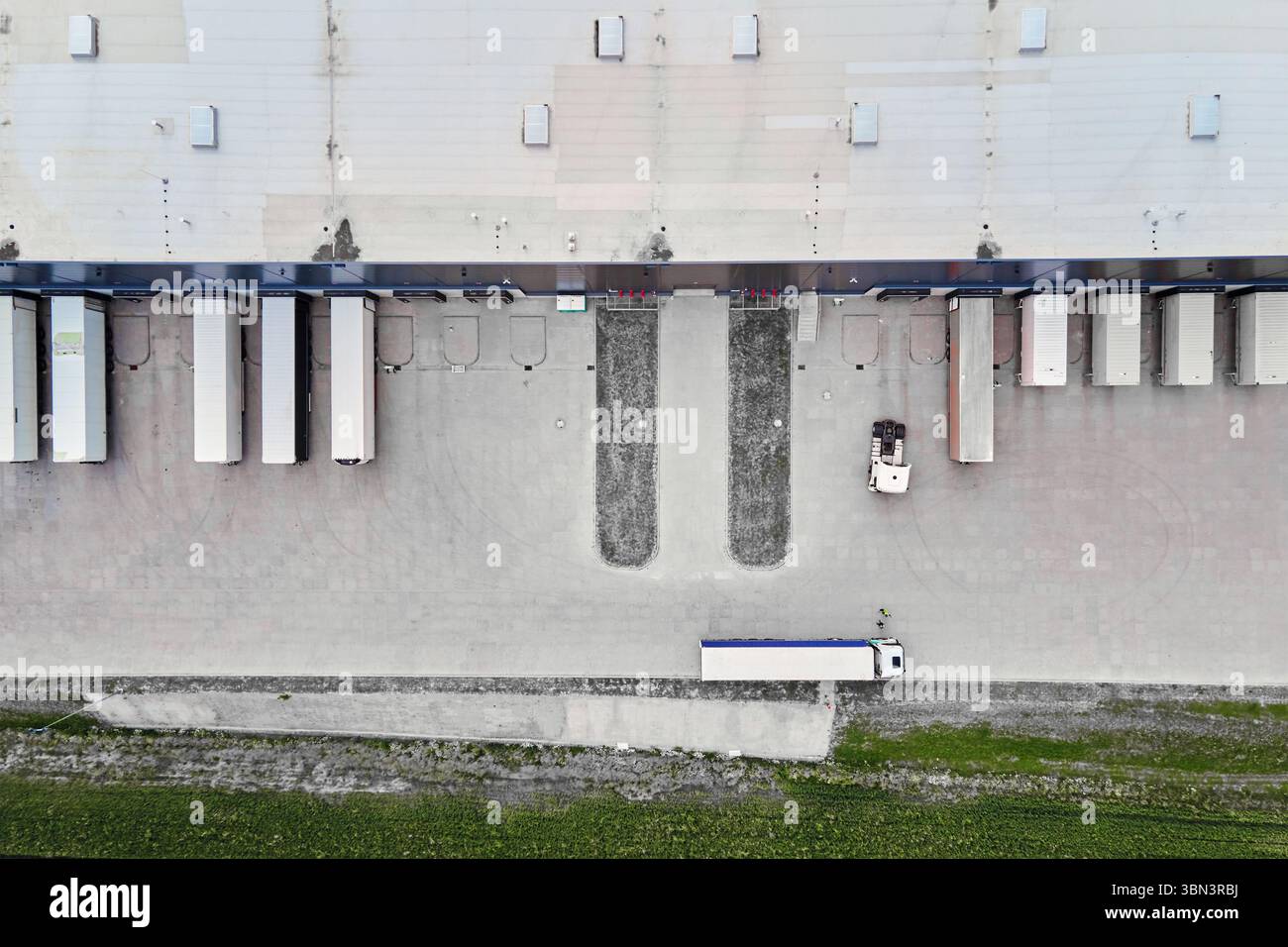 Aerial view of warehouse loading platforms with parked trailers and cargo trucks in operation. Modern logistics infrastructure Stock Photo