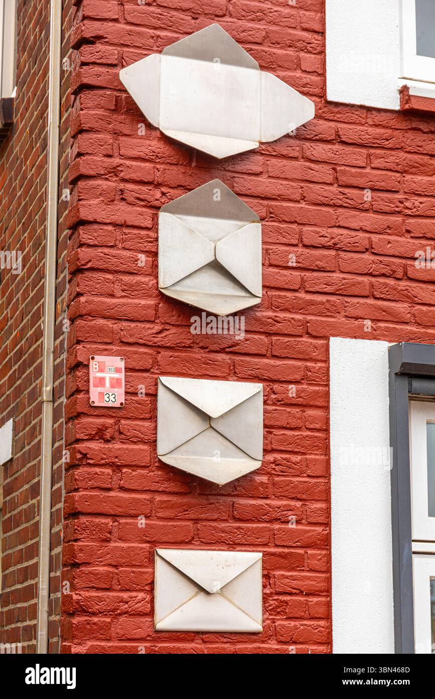 Folding a metal envelope on a red brick wall Stock Photo