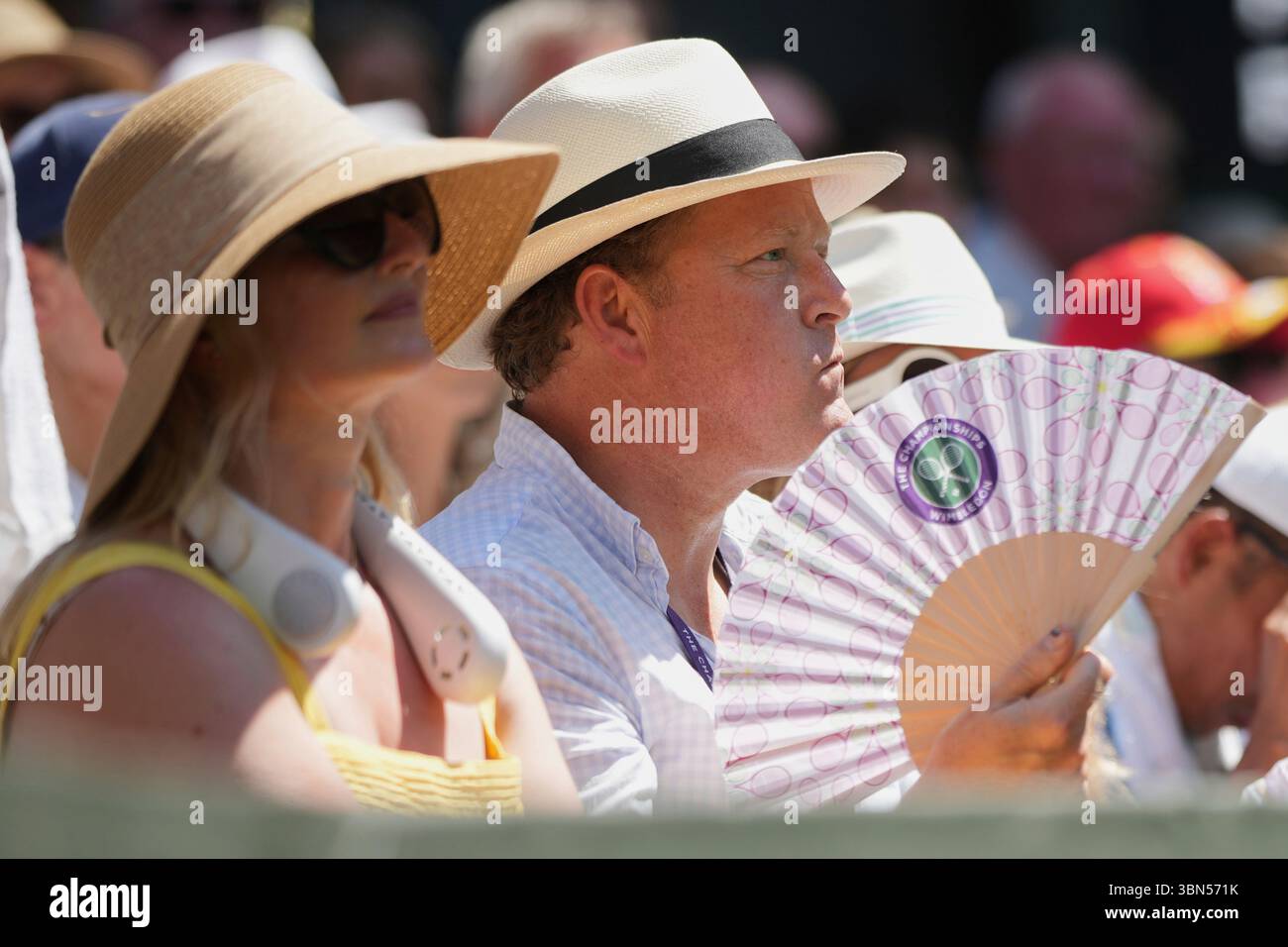A spectator fans himself on Centre Court on day one at the Wimbledon ...