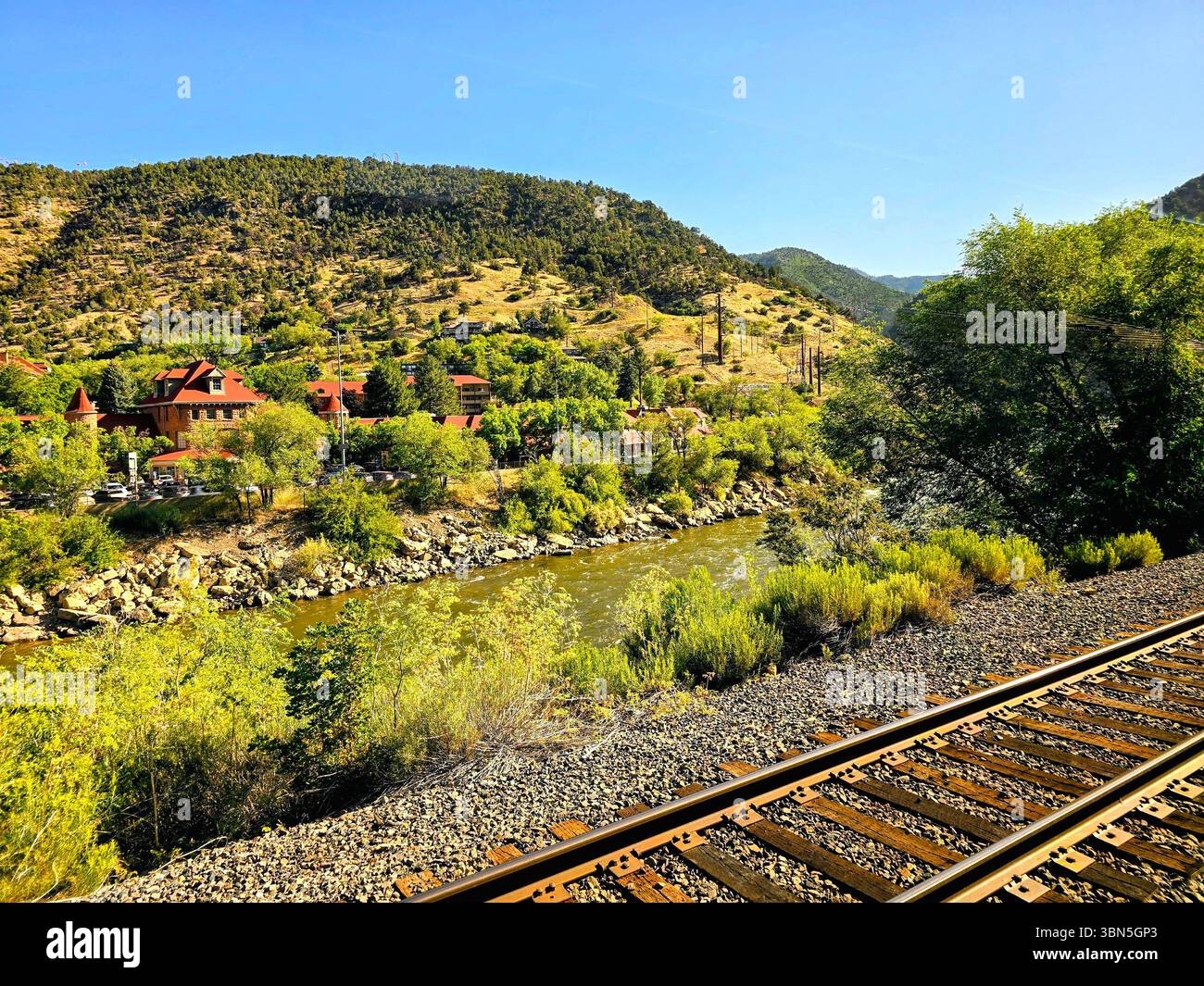 Rushing river carving through steep forested cliffs in the rugged mountain terrain of Colorado. - Smartphone Captured Stock Image