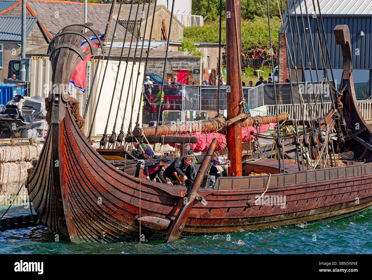 Viking ship the Draken Harald Harfagre crew members fixing rudder in ...