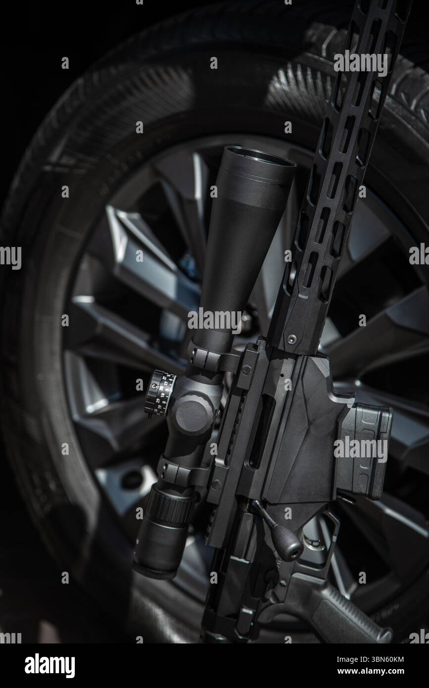 Tactical sniper rifle with scope leaning against car wheel Stock Photo ...
