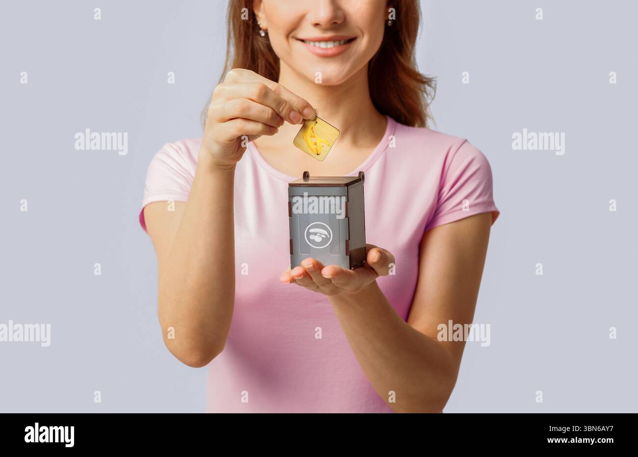 Woman engages in eco-friendly recycling activity with a smile Stock Photo