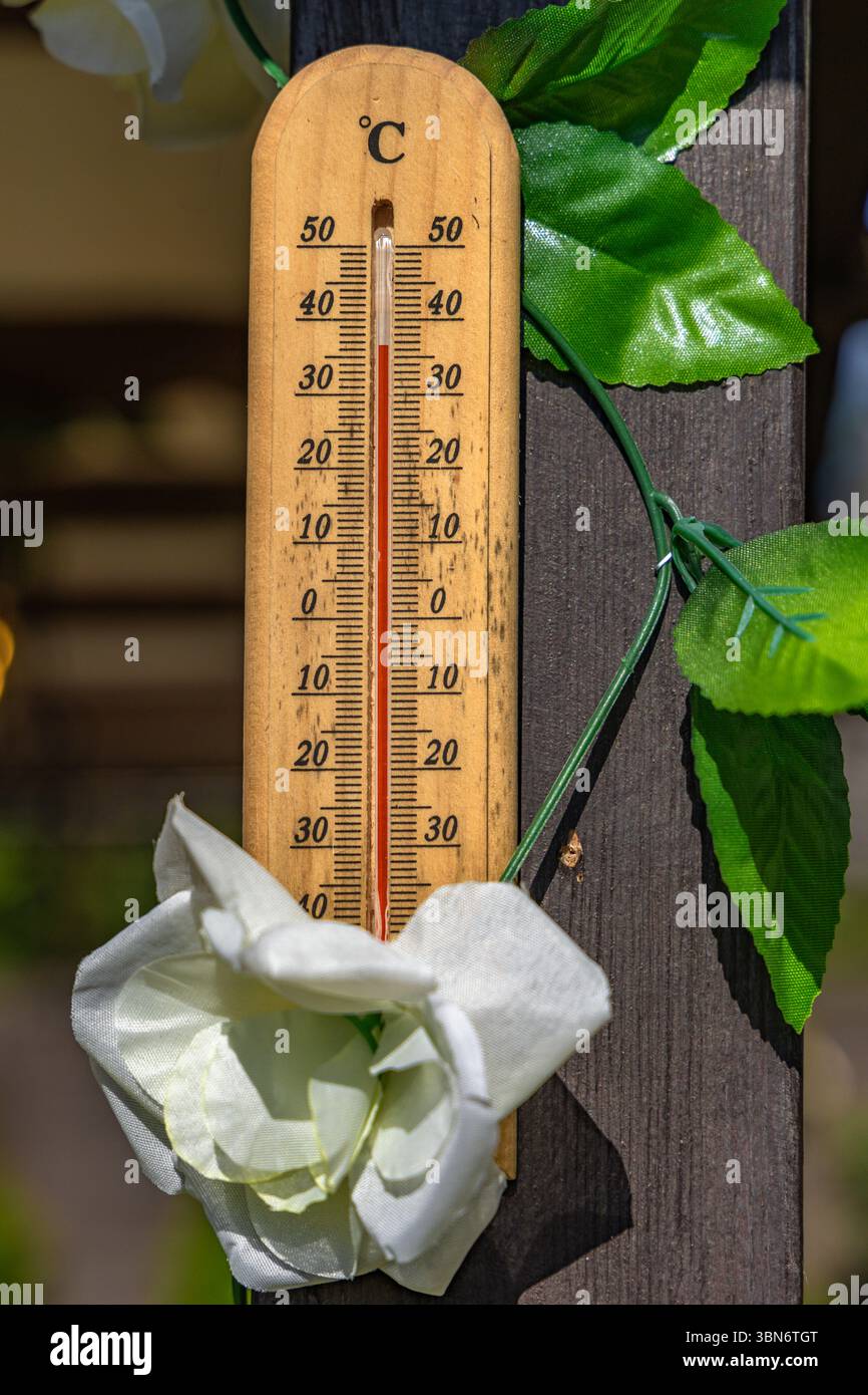 Wooden mercury thermometer showing very high temperature in summer on the front porch, a heat wave dangerous to health Stock Photo