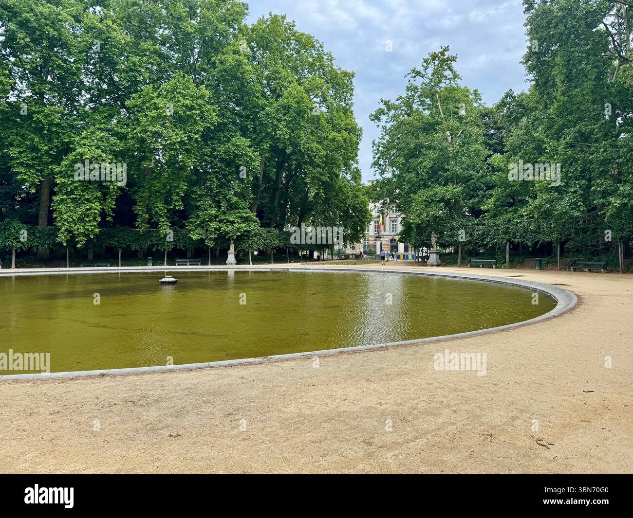 Circular ornamental pond surrounded by trees in a public park in Brussels, Belgium. - Smartphone Captured Stock Image Circular ornamental pond surrounded by trees in a public park in Brussels, Belgium. - Smartphone Captured Stock Image