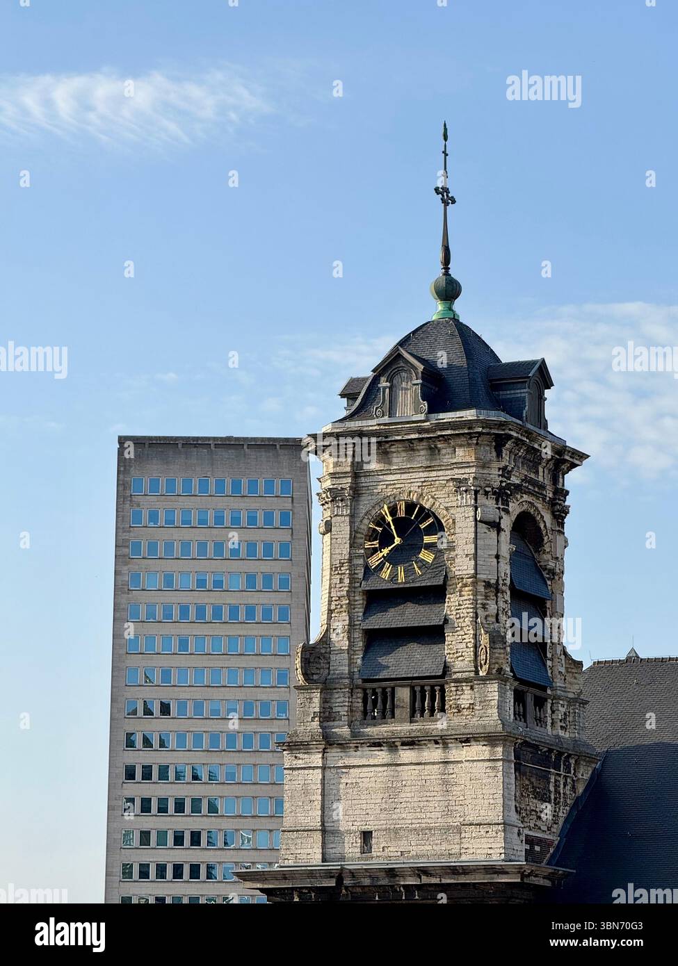 Historic clock tower juxtaposed with a modern office high‑rise in Brussels, Belgium. - Smartphone Captured Stock Image